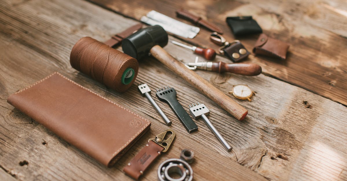 Leather wallet and crafting tools arranged on a wooden workbench.