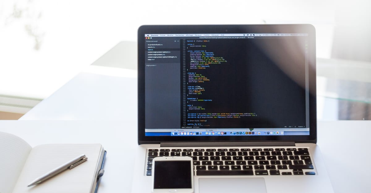 Open laptop displaying code on a minimal desk.